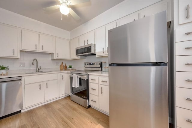 kitchen featuring ceiling fan, sink, light hardwood / wood-style floors, white cabinets, and appliances with stainless steel finishes