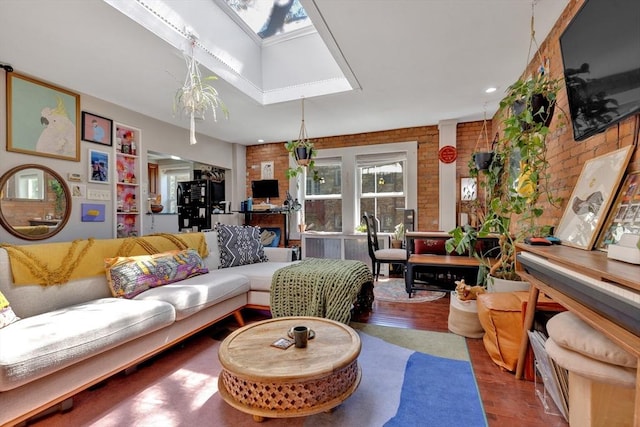 living room with a skylight, brick wall, and wood finished floors