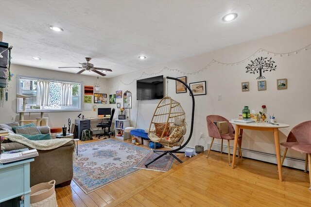 living area featuring recessed lighting, a ceiling fan, and a baseboard heating unit