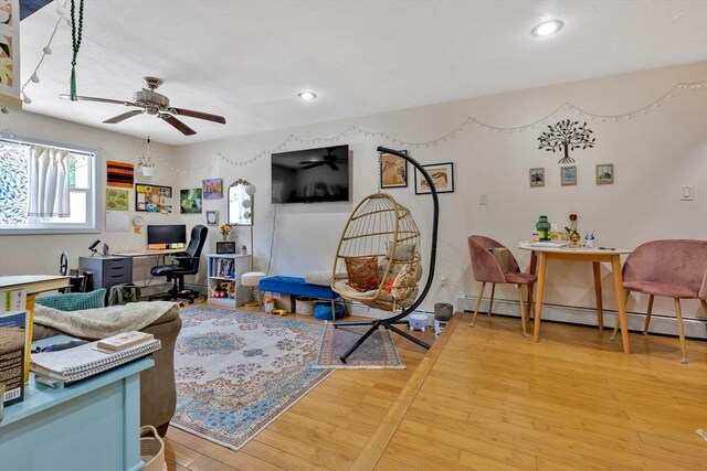 living area with recessed lighting, a ceiling fan, light wood finished floors, and a baseboard heating unit