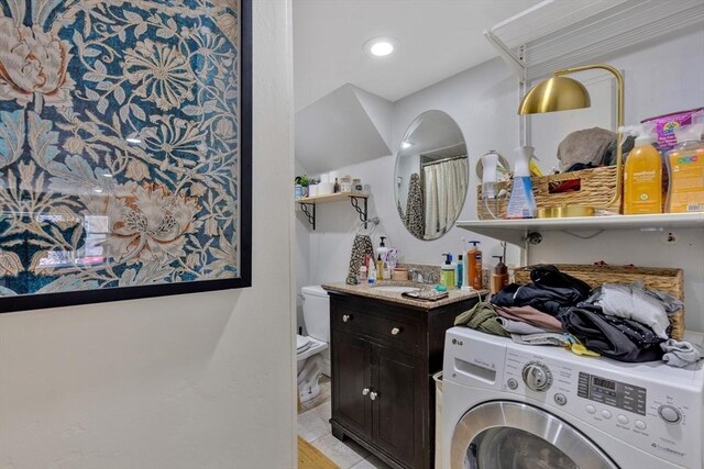 washroom featuring laundry area, a sink, and washer / clothes dryer