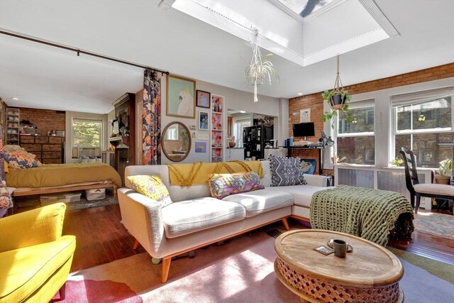 living area featuring brick wall and hardwood / wood-style floors