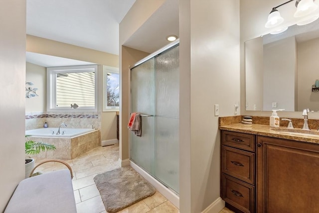 bathroom featuring tile patterned flooring, vanity, baseboards, a shower stall, and a garden tub