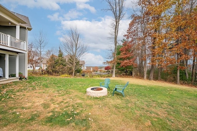 view of yard featuring a fire pit and a balcony