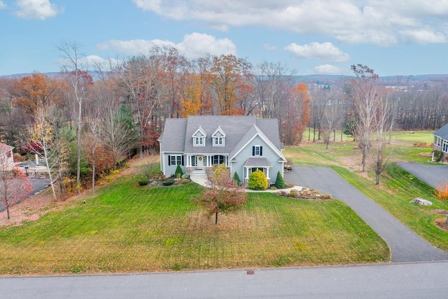 view of front facade with a porch, aphalt driveway, and a front yard