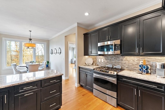 kitchen with light stone counters, light wood-style floors, stainless steel appliances, baseboards, and backsplash