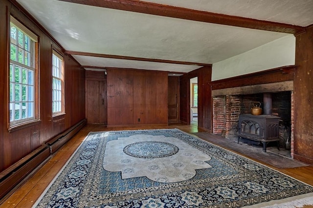 40 Whately Glen Rd, Conway, MA 01341 - living area featuring wood-type flooring, a wood stove, wood walls, plenty of natural light, and a baseboard radiator