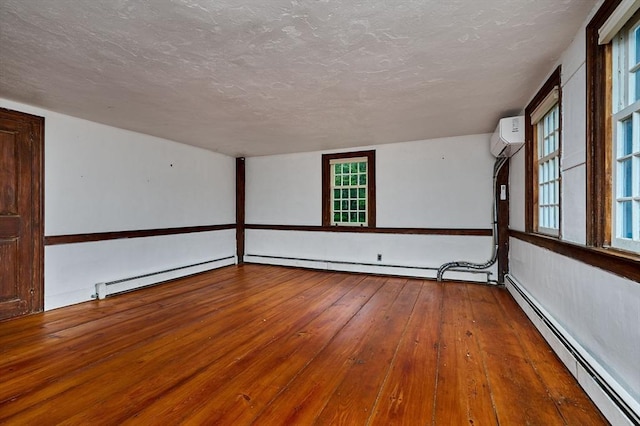40 Whately Glen Rd, Conway, MA 01341 - spare room featuring a baseboard heating unit, hardwood / wood-style floors, a textured ceiling, and a wall unit AC