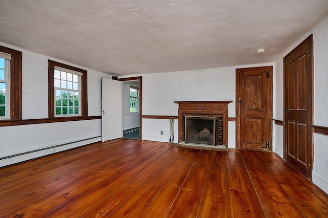 40 Whately Glen Rd, Conway, MA 01341 - unfurnished living room featuring wood-type flooring, a brick fireplace, and a baseboard heating unit