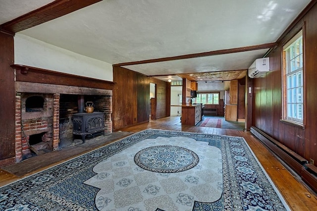 40 Whately Glen Rd, Conway, MA 01341 - unfurnished living room with wood walls, hardwood / wood-style flooring, a wood stove, and a wall mounted air conditioner