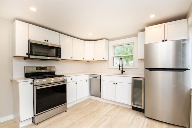 67 Thatcher St, Brockton, MA 02302 - kitchen with appliances with stainless steel finishes, beverage cooler, a sink, light countertops, and recessed lighting