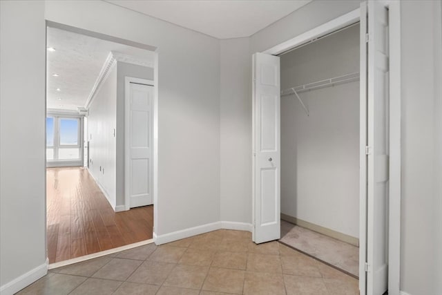 unfurnished bedroom with light hardwood / wood-style flooring, a closet, and ornamental molding