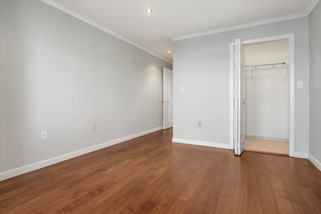 unfurnished bedroom with crown molding, hardwood / wood-style floors, and a closet