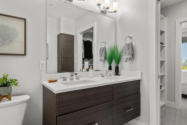 130 Broad Reach Unit 409, Weymouth, MA 02191 - bathroom with double vanity, a walk in closet, toilet, and baseboards
