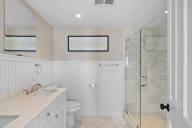 bathroom featuring visible vents, wainscoting, toilet, marble finish floor, and a sink