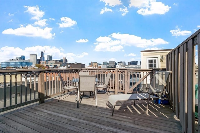 deck featuring a view of city and outdoor dining space