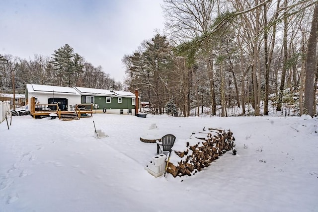 yard covered in snow with a deck