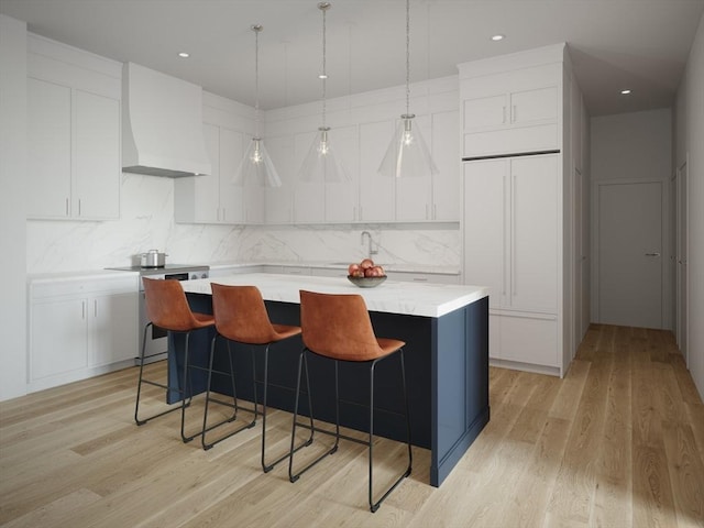 kitchen with light countertops, premium range hood, light wood-style floors, a center island, and range