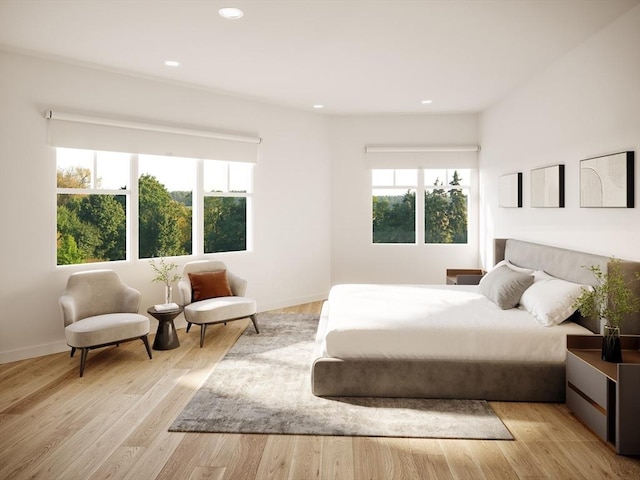 bedroom featuring recessed lighting, light wood finished floors, and multiple windows