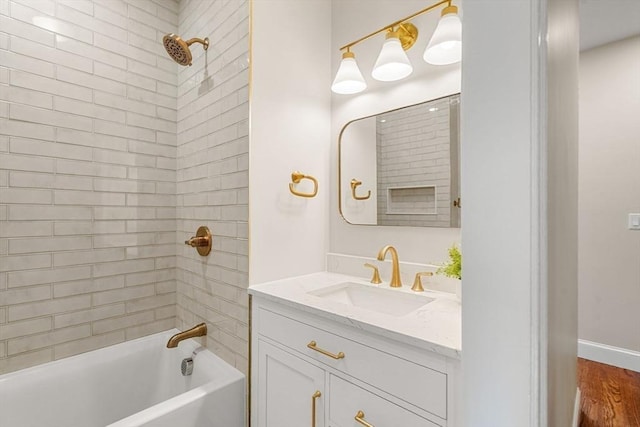 bathroom featuring vanity, hardwood / wood-style floors, and tiled shower / bath