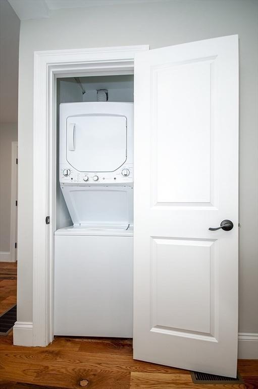89 Morris St, Boston, MA 02128 - washroom with stacked washer / drying machine and wood finished floors