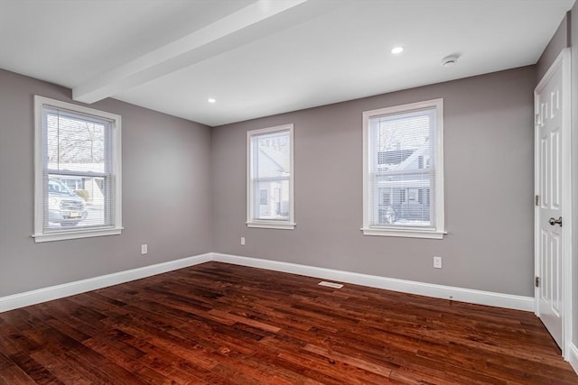 unfurnished room featuring beamed ceiling and dark hardwood / wood-style floors