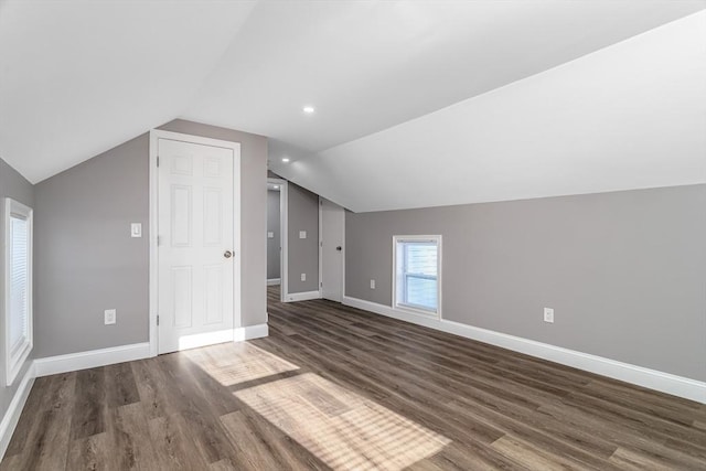 additional living space with dark hardwood / wood-style floors and vaulted ceiling