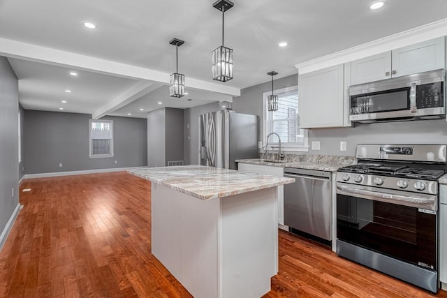 kitchen with white cabinetry, a center island, sink, stainless steel appliances, and hardwood / wood-style floors