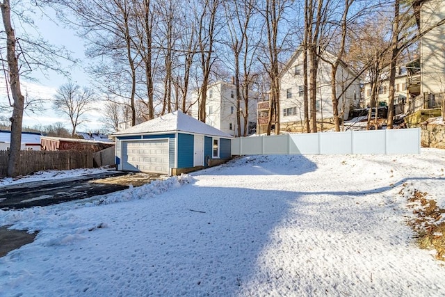 yard layered in snow with a garage and an outdoor structure