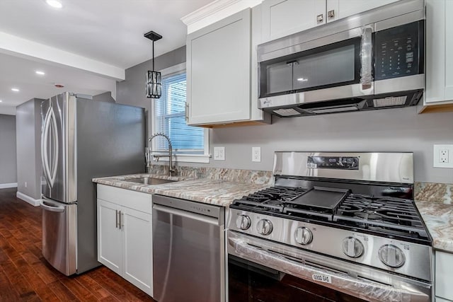 kitchen with light stone countertops, white cabinetry, dark wood-type flooring, and appliances with stainless steel finishes