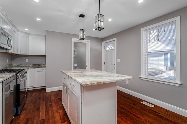 kitchen with dark hardwood / wood-style flooring, stainless steel appliances, pendant lighting, white cabinets, and a center island