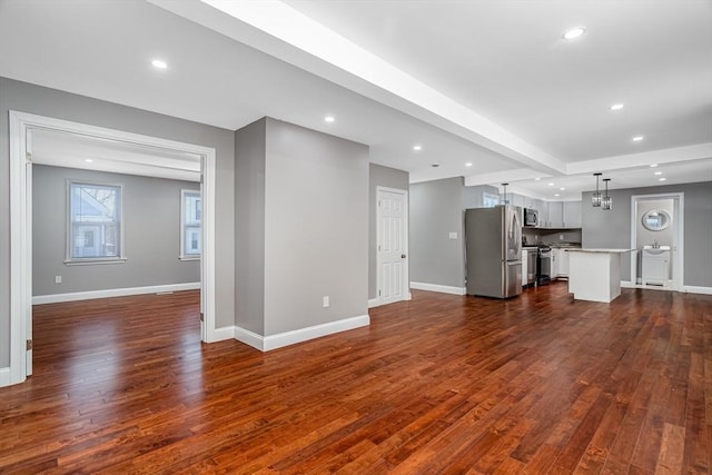 unfurnished living room with beam ceiling and dark wood-type flooring