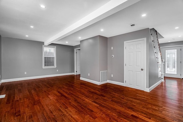 interior space with beam ceiling and dark wood-type flooring