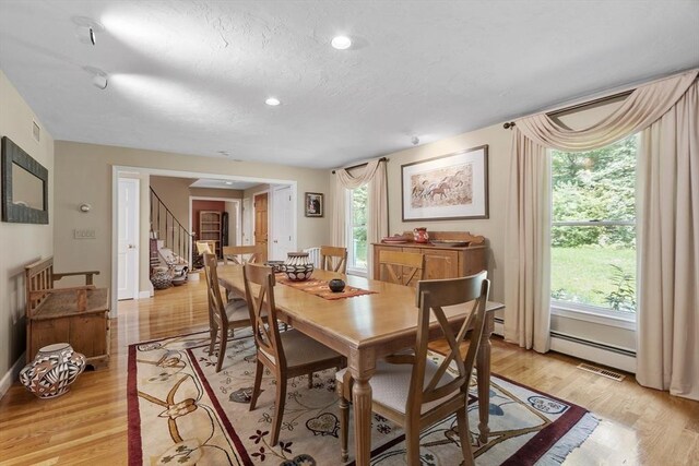 kitchen featuring light wood-type flooring, tasteful backsplash, light stone counters, sink, and washer / dryer