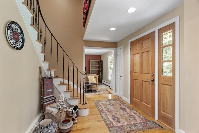 entrance foyer with baseboard heating and light hardwood / wood-style floors