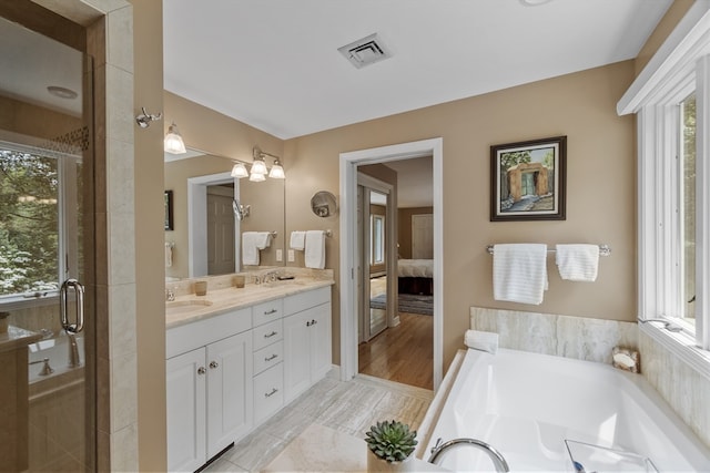 bathroom featuring plus walk in shower, wood-type flooring, and vanity