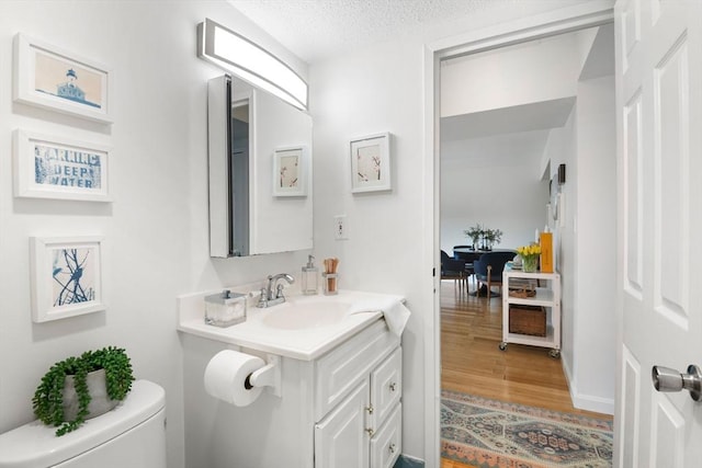 135 Pleasant St Unit 403, Brookline, MA 02446 - bathroom featuring vanity, wood finished floors, and a textured ceiling