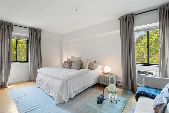 135 Pleasant St Unit 403, Brookline, MA 02446 - bedroom featuring wood finished floors and a baseboard heating unit