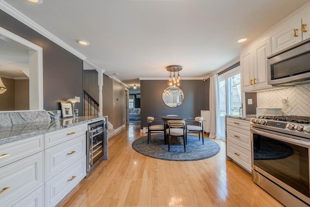 37 Hillcrest Ave, Methuen, MA 01844 - kitchen with appliances with stainless steel finishes, beverage cooler, white cabinets, crown molding, and backsplash