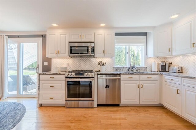 37 Hillcrest Ave, Methuen, MA 01844 - kitchen with stainless steel appliances, a sink, tasteful backsplash, light stone counters, and white cabinetry
