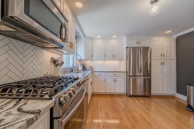 37 Hillcrest Ave, Methuen, MA 01844 - kitchen with appliances with stainless steel finishes, a sink, white cabinets, backsplash, and recessed lighting