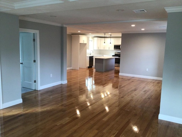 unfurnished living room with hardwood / wood-style flooring, ornamental molding, and sink