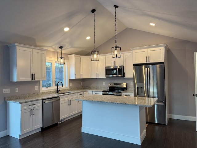 kitchen with decorative light fixtures, white cabinetry, and stainless steel appliances