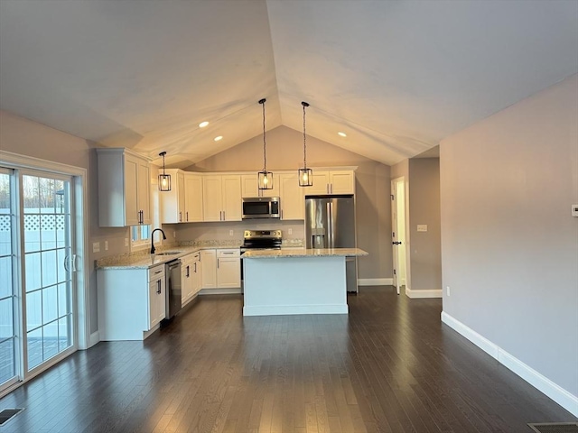 kitchen with white cabinetry, stainless steel appliances, a kitchen island, pendant lighting, and sink