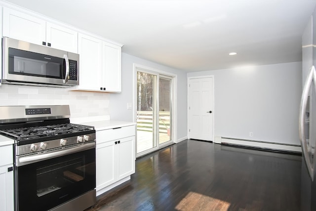 kitchen with a baseboard radiator, appliances with stainless steel finishes, white cabinets, and dark hardwood / wood-style flooring