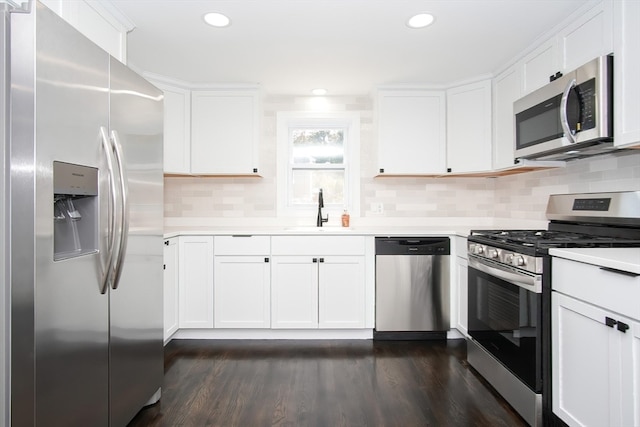 kitchen featuring appliances with stainless steel finishes, white cabinetry, sink, and dark hardwood / wood-style flooring