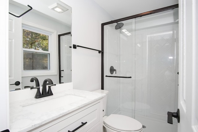 bathroom featuring vanity, toilet, and walk in shower