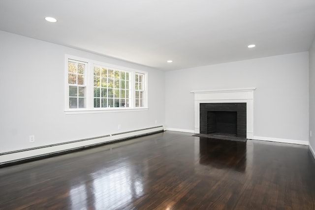 unfurnished living room featuring a baseboard heating unit, a brick fireplace, and dark hardwood / wood-style flooring