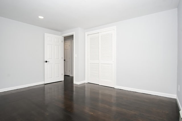 unfurnished bedroom featuring a closet and dark hardwood / wood-style floors