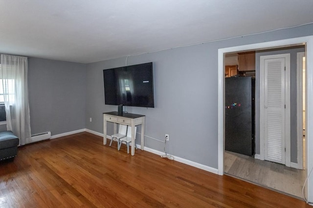 67 Donbray Rd, Springfield, MA 01119 - unfurnished living room with wood finished floors, baseboards, and a baseboard heating unit